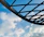 Close-up of a sleek blue steel canopy installed over a carport with a clear sky background.