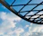 Close-up of a sleek blue steel canopy installed over a carport with a clear sky background.