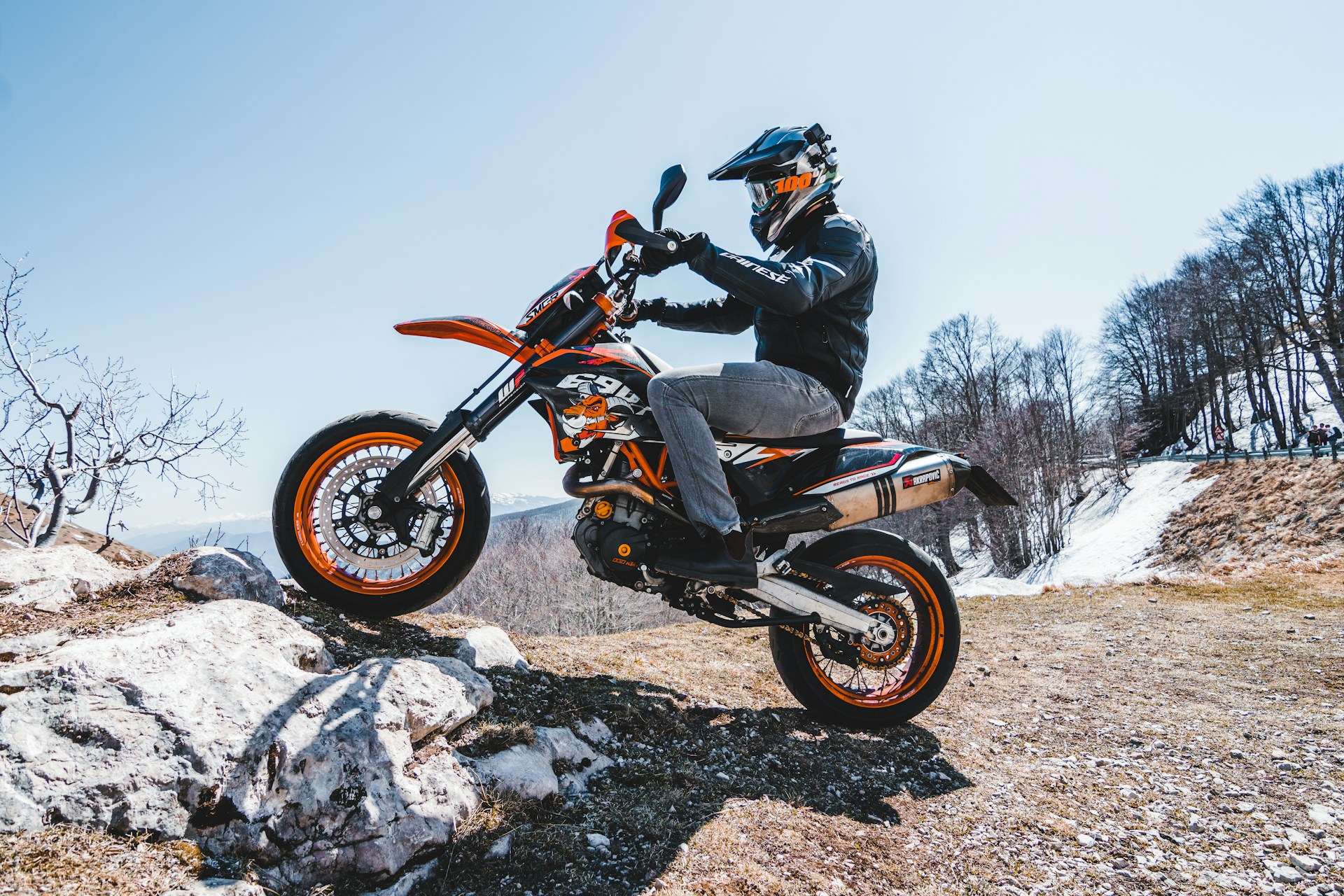 man riding orange and black dirt bike during daytime