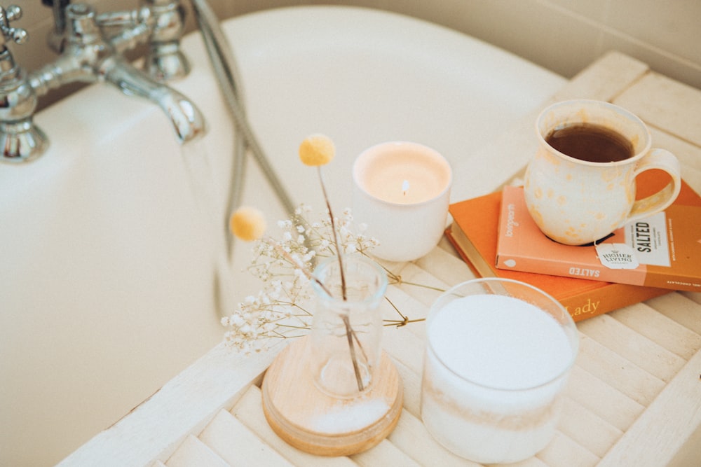 una tazza di caffè e alcuni libri su una vasca da bagno
