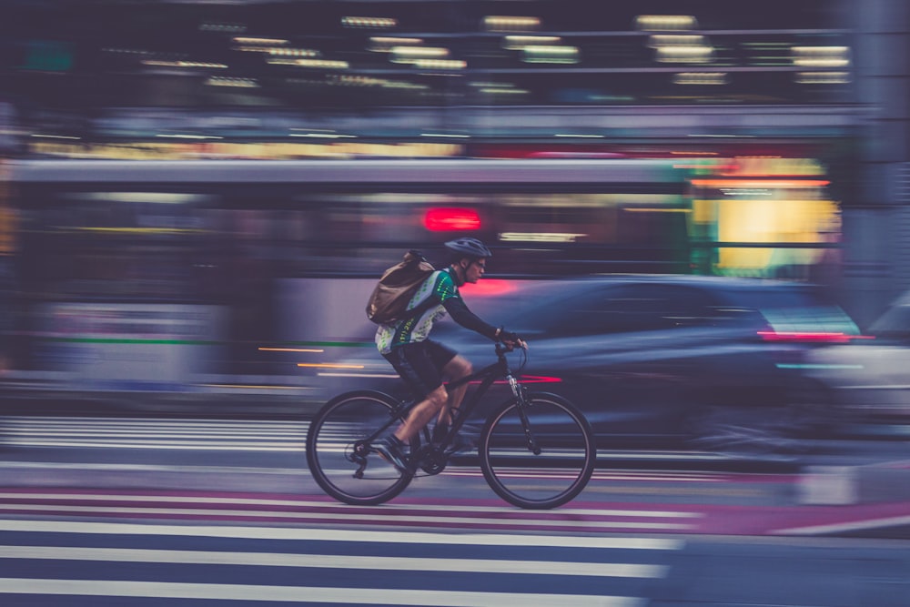 man riding bicycle on road in time lapse photography