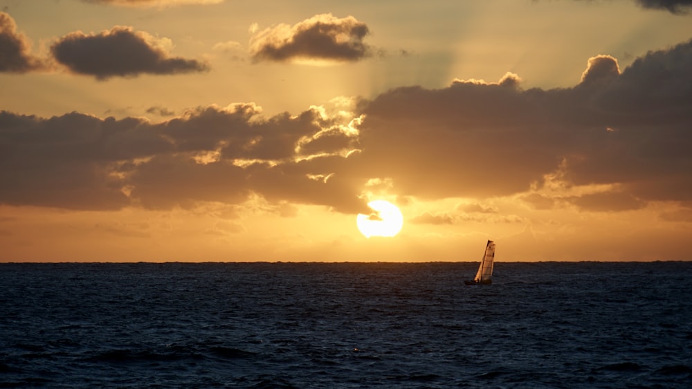 sail boat under orange sky