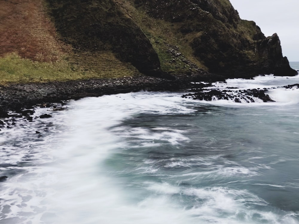 clear blue sea beside rock formation