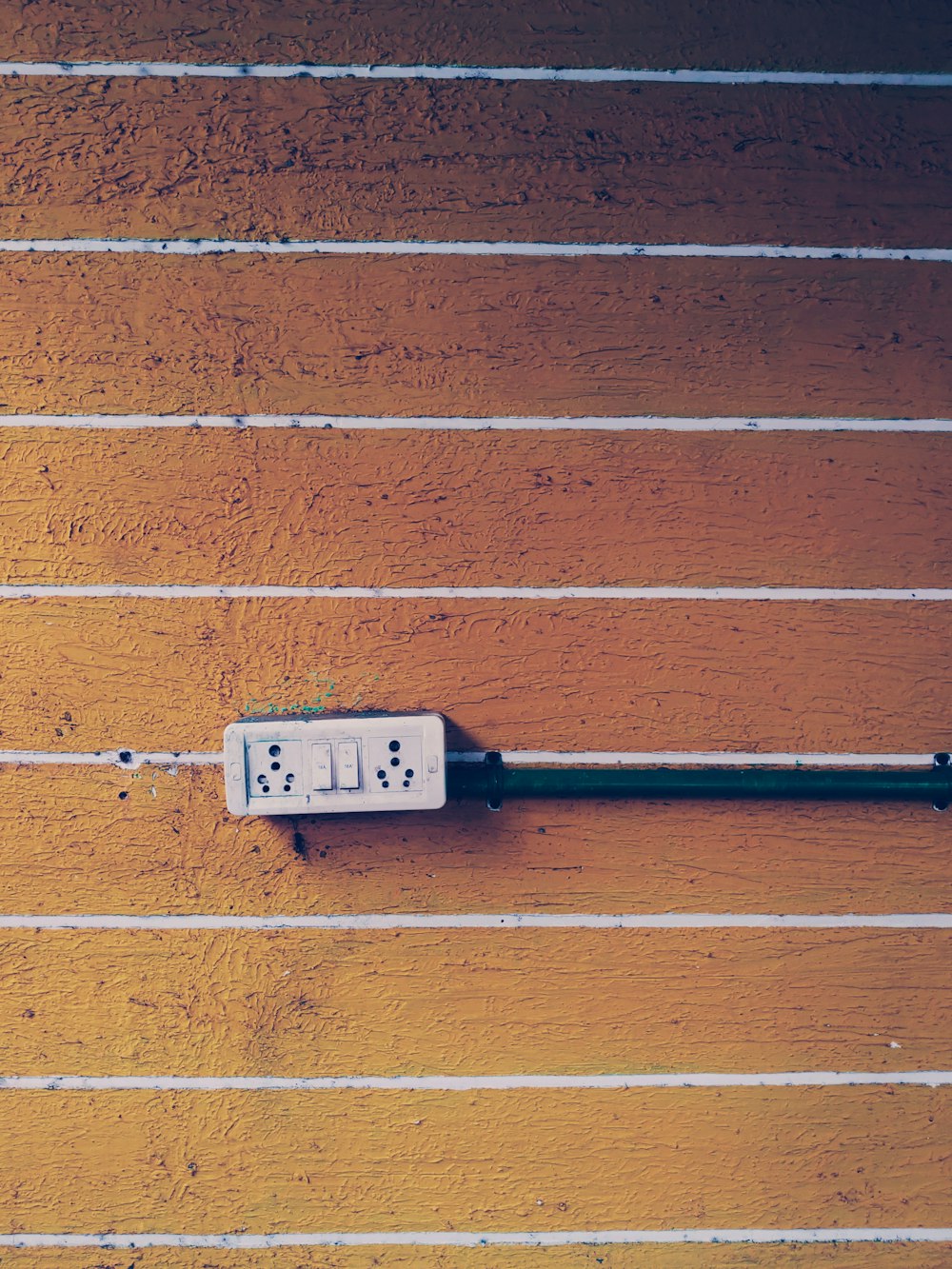 a white electrical outlet on a wooden wall