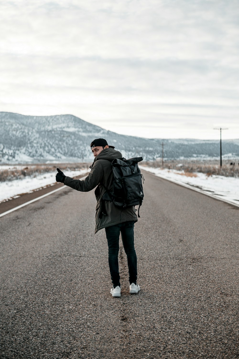 man standing on asphalt road