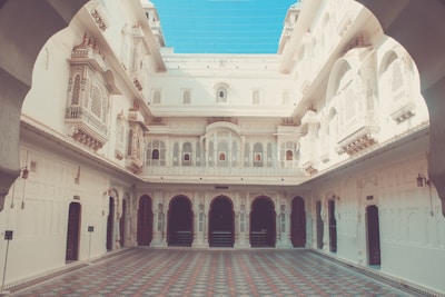 An elegant villa with traditional Brij architecture, featuring carved wooden doors and a courtyard.