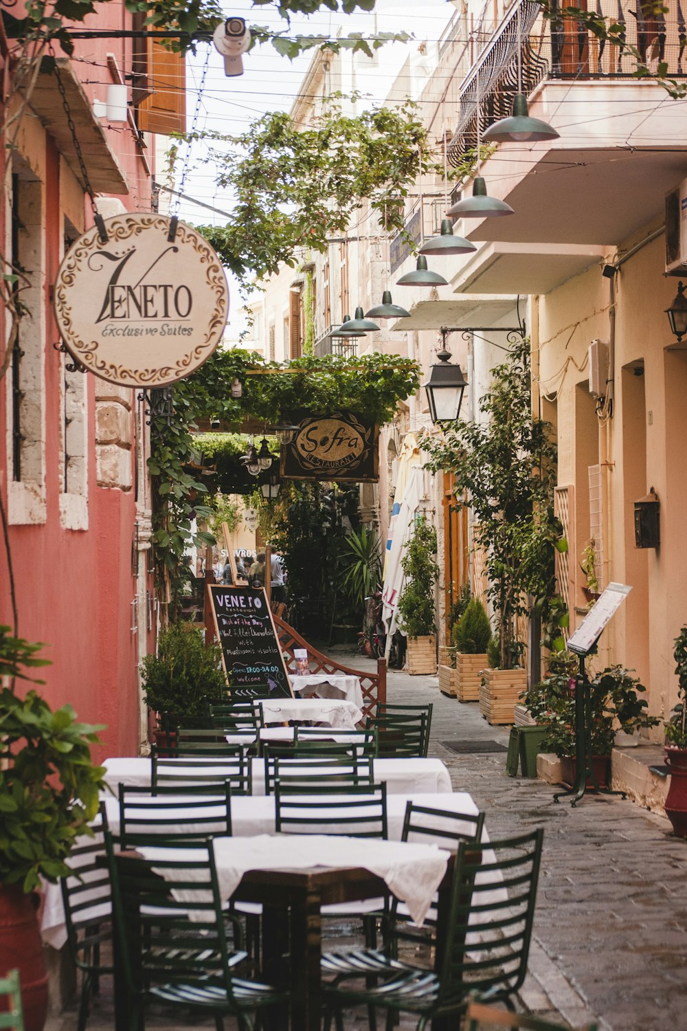 a narrow alleyway with tables and chairs