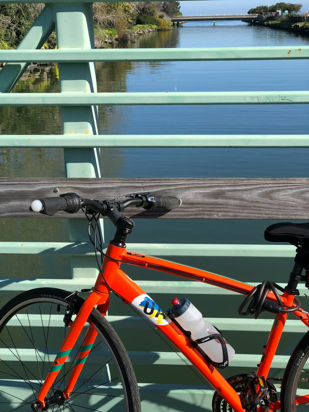 orange rigid bike on bridge