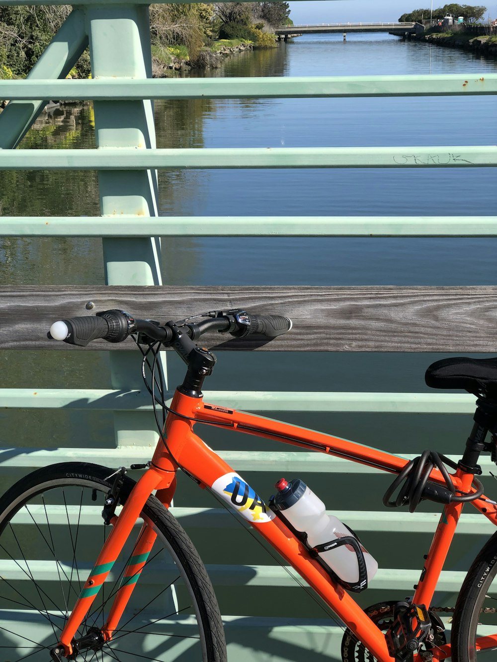 orange rigid bike on bridge