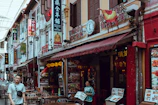 Wide shot of a busy street with multiple restaurants using LED menu displays.