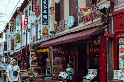 Wide shot of a busy street with multiple restaurants using LED menu displays.