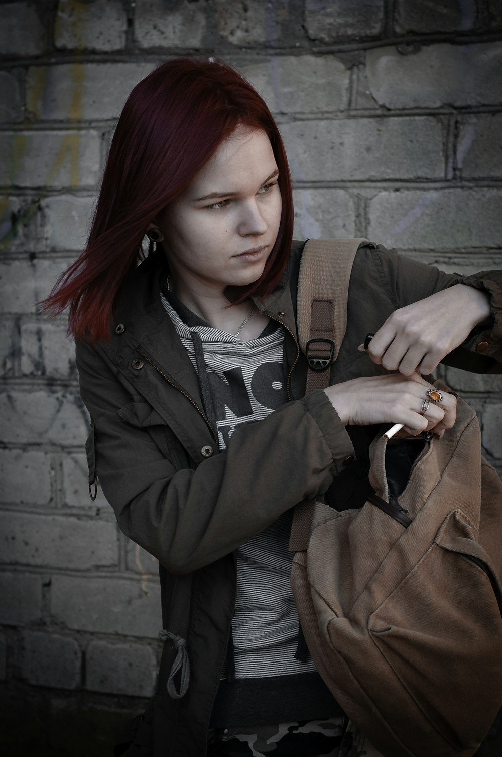 a woman with red hair is holding a bag