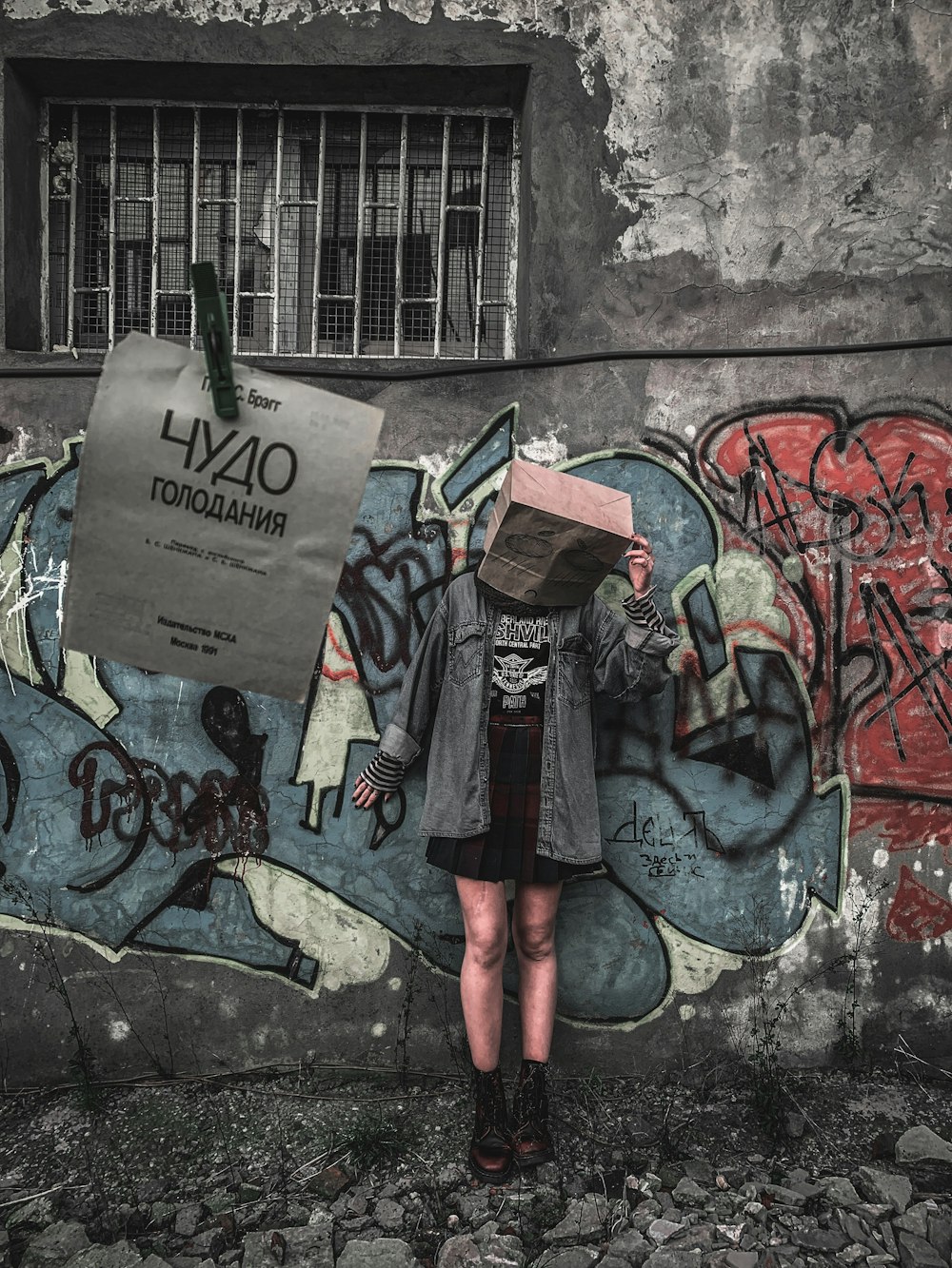 Una mujer parada frente a una pared cubierta de graffiti