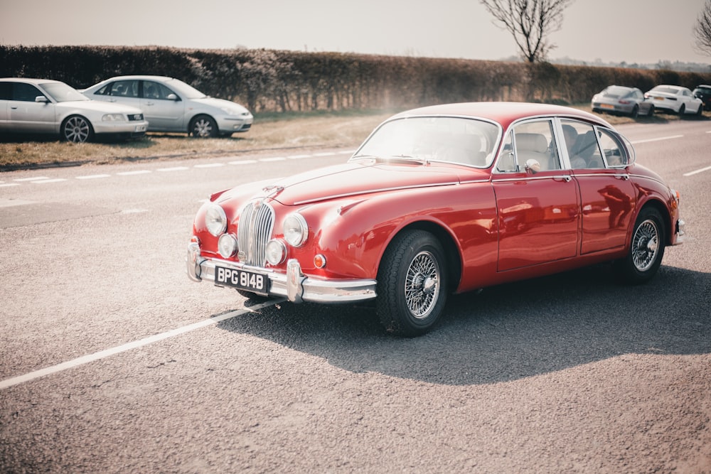 BERLINE ROUGE CLASSIQUE SUR LA ROUTE PENDANT LA JOURNÉE