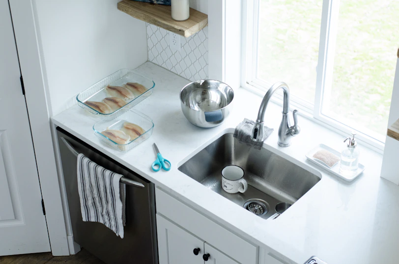 Organized kitchen sink with soap dispensers and a drying rack