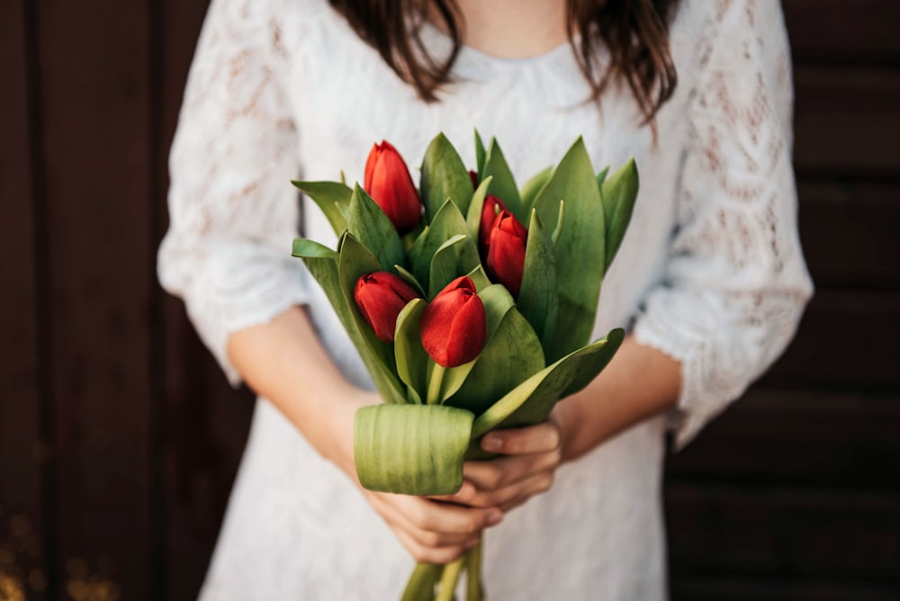 Person mit roten Tulpenblüten