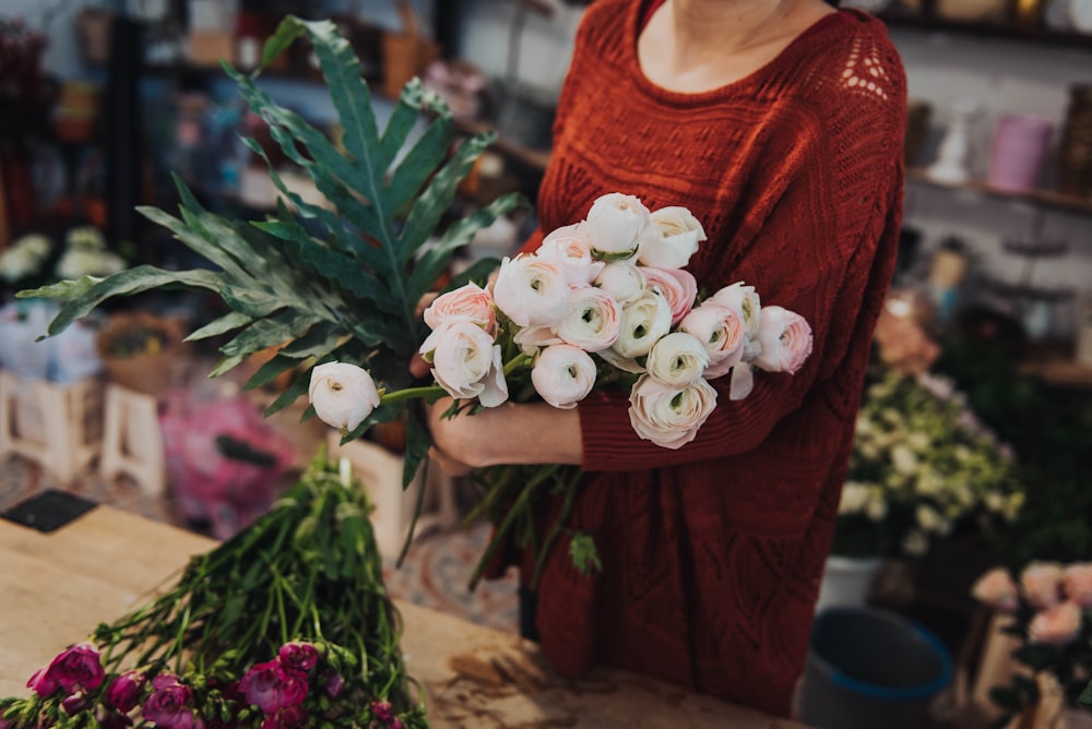 woman carrying white and pink petaled flower bouquet