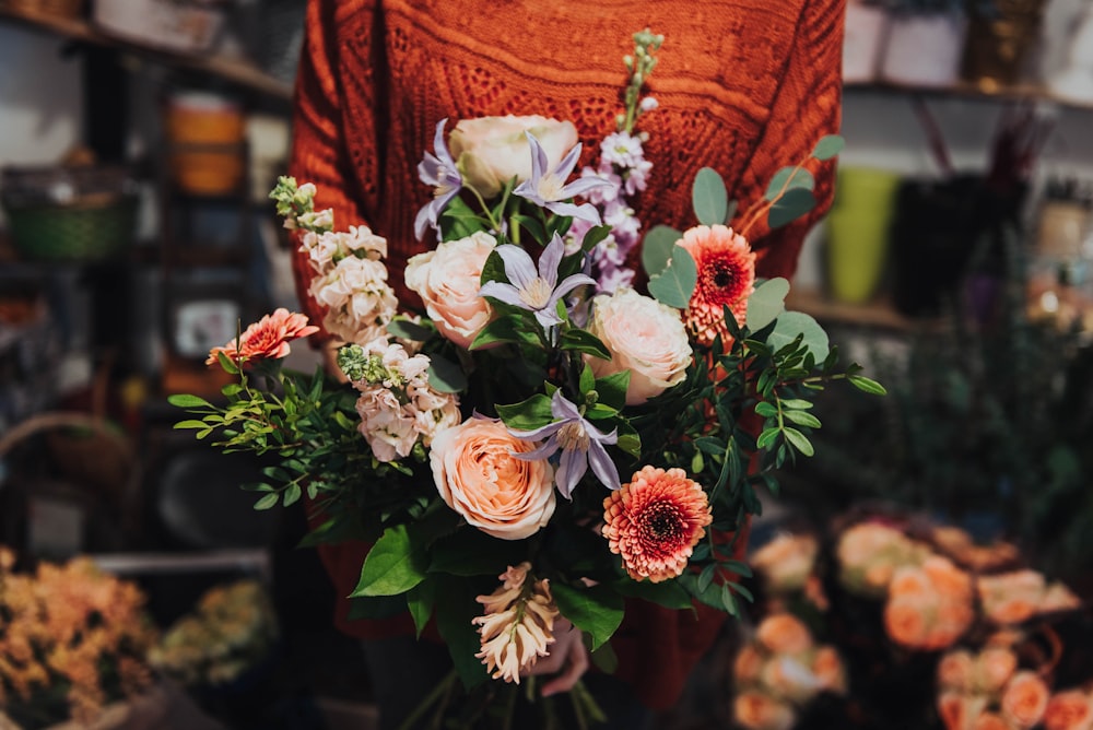 selective focus photo of woman holding bouquet of flower