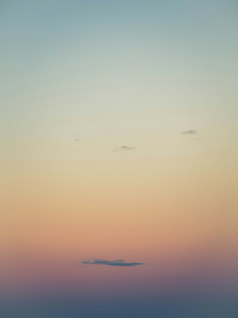 a plane flying in the sky at sunset