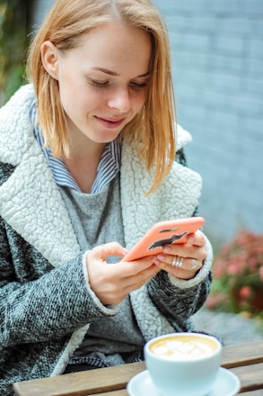 woman smiling while using her phone