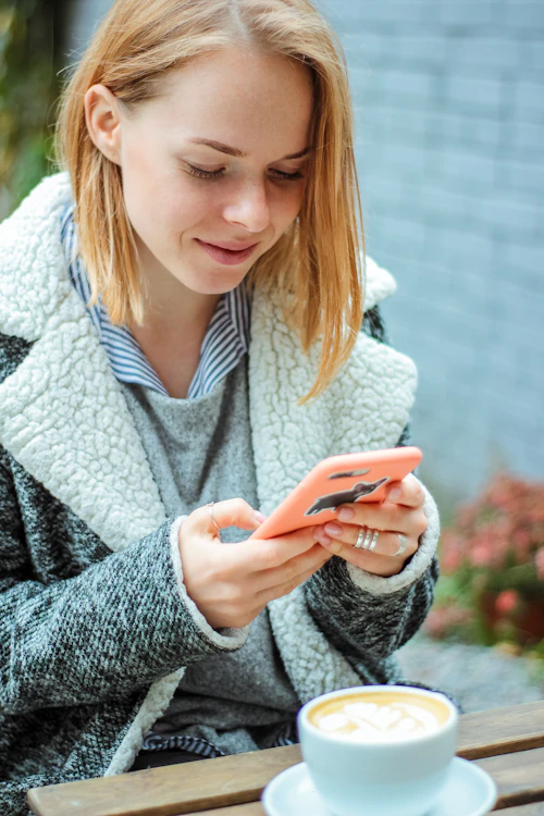 free lds dating apps – woman messaging on her phone with coffee