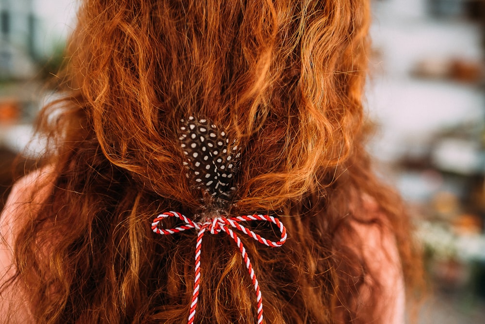 person with red and white bow hair tie on hair