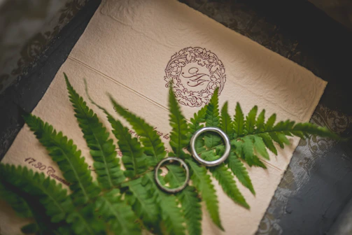 Close-up of gently wrinkled parchment with subtle gold wave accents and a faint emerald green floral motif.