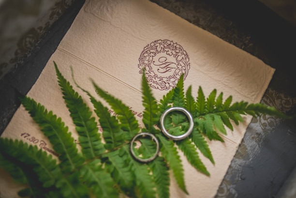 A close-up of a beautifully designed couple logo featuring intertwined initials with floral accents.