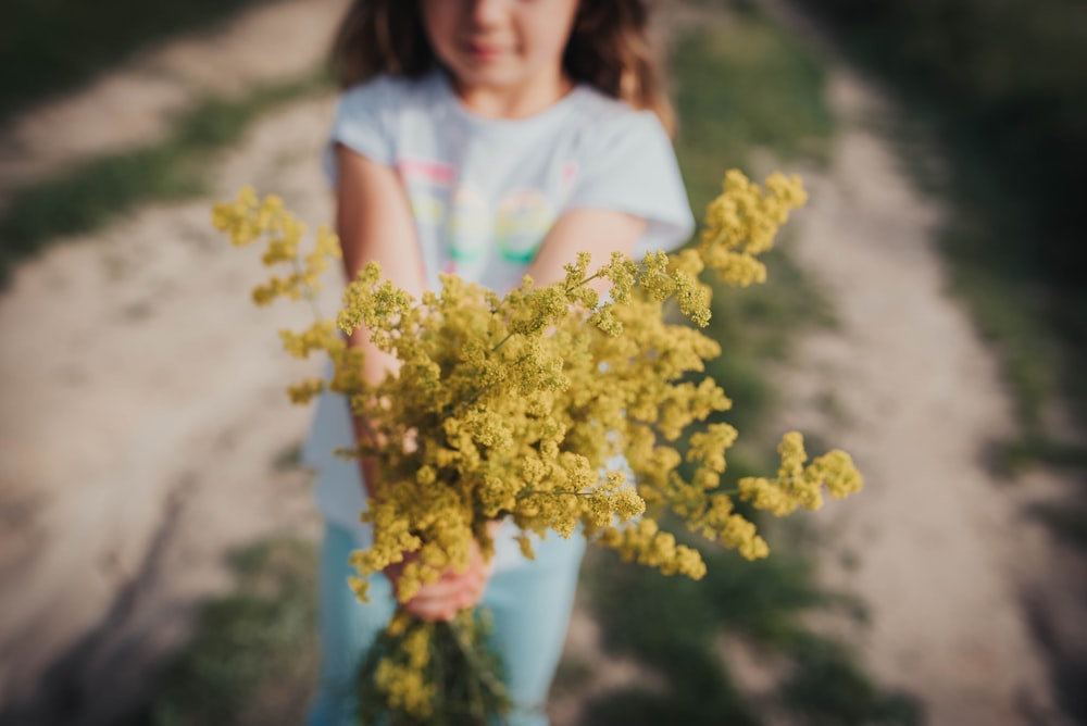 girl holding yellow flower bouquet