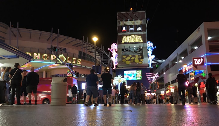 A bustling downtown Las Vegas street scene at sunset with diverse people engaging in daily activities.