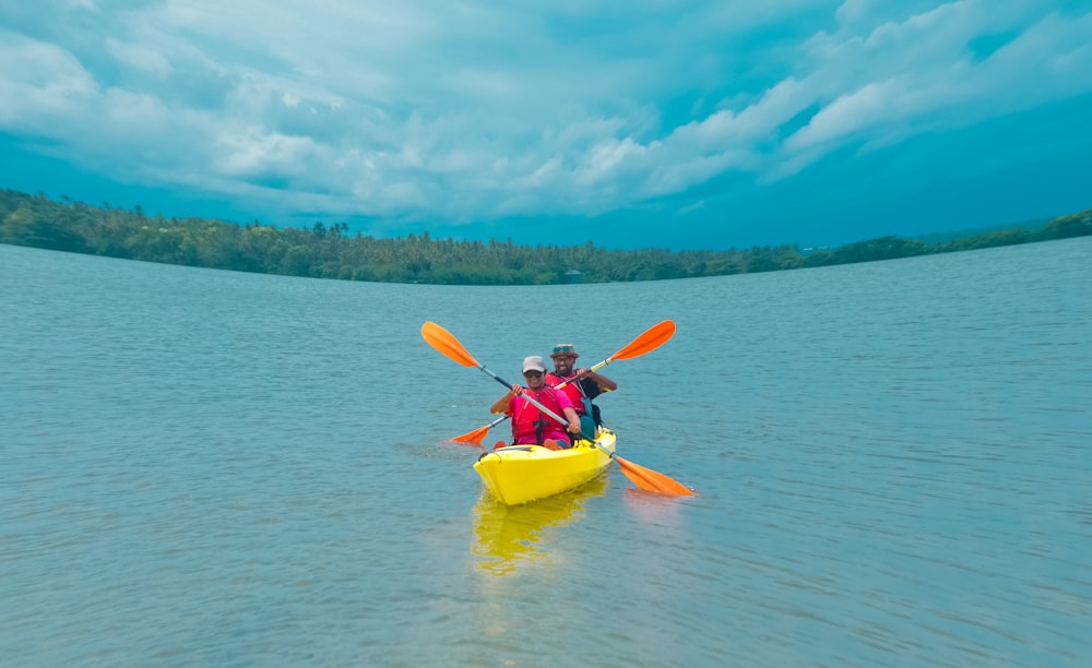 two person paddling kayak on calm sea during daytime