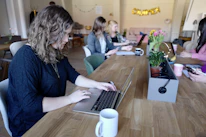 A group of diverse writers collaborating over coffee in a cozy office.