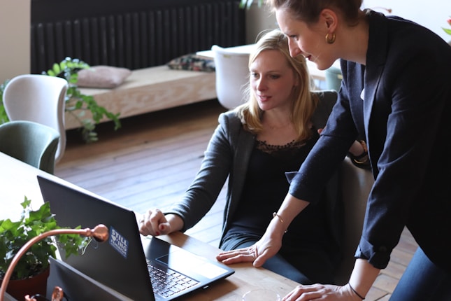 two woman looking at laptop screen