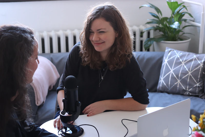 Duas profissionais conversam durante uma entrevista gravada com microfone de podcast