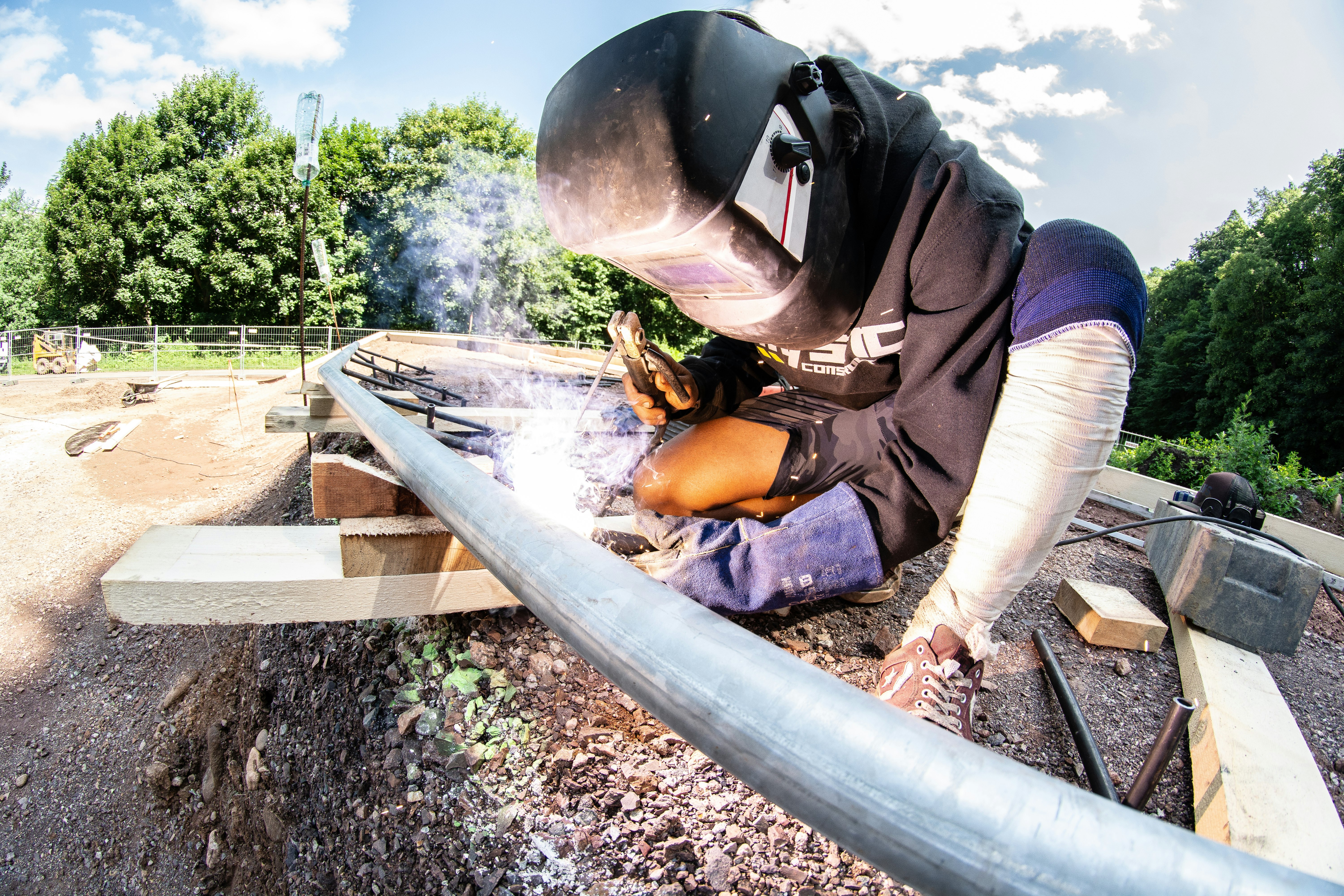 man welding metal pipe