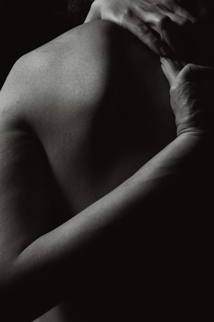 Close-up of hands gently massaging a shoulder, highlighting tenderness and care.