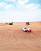 Elegant white SUV ready for an adventure with desert dunes in the background.