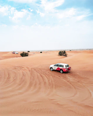 Elegant white SUV ready for an adventure with desert dunes in the background.
