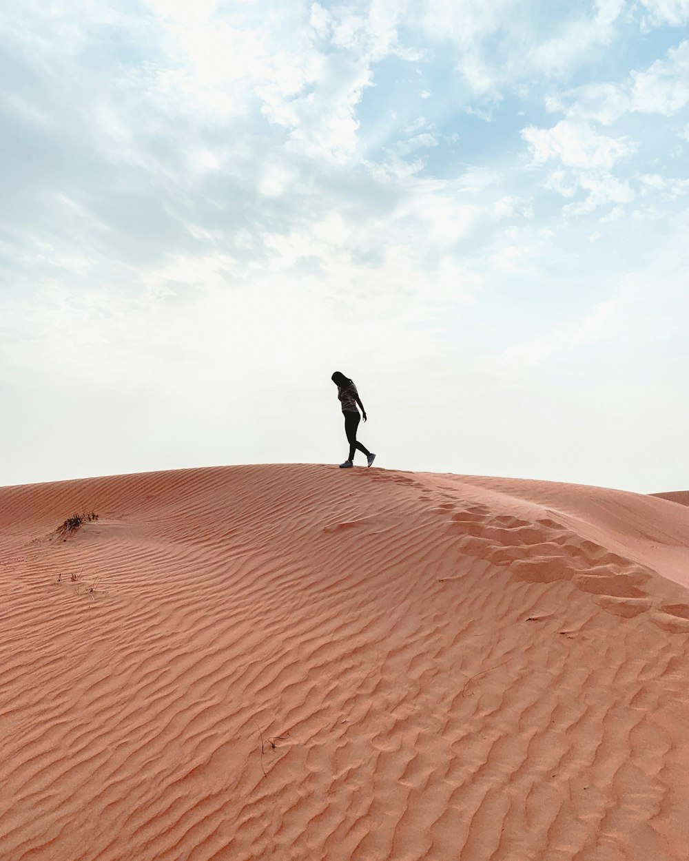 silhouette of woman walking on desert