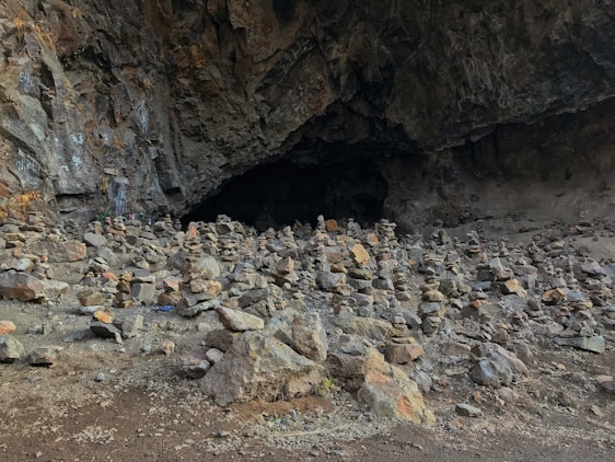 A mysterious cave entrance with treasure chests scattered around.