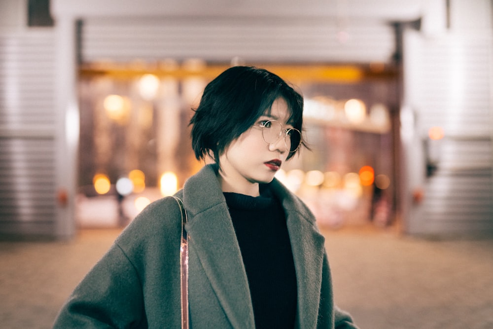 woman wearing coat standing near shopping mall