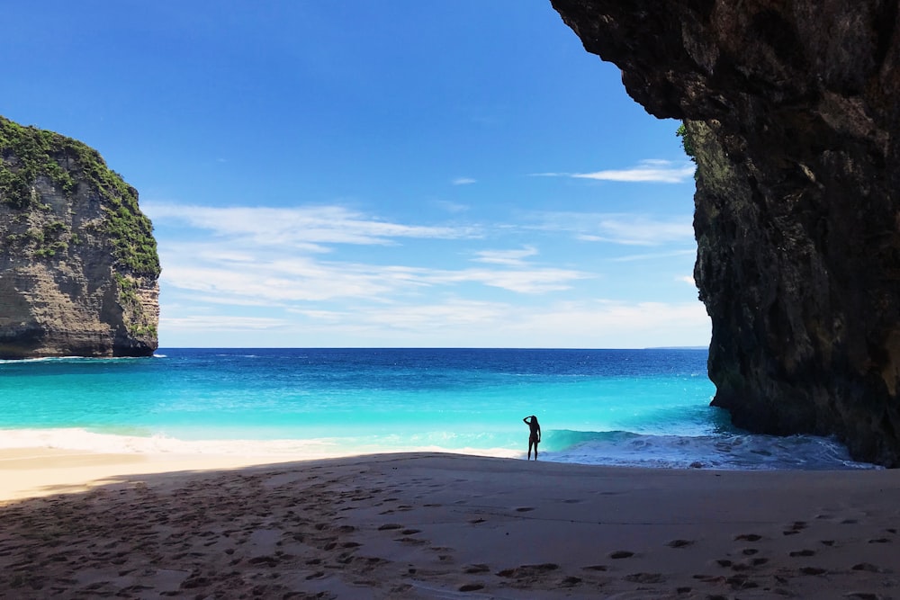 person standing on shore during daytime