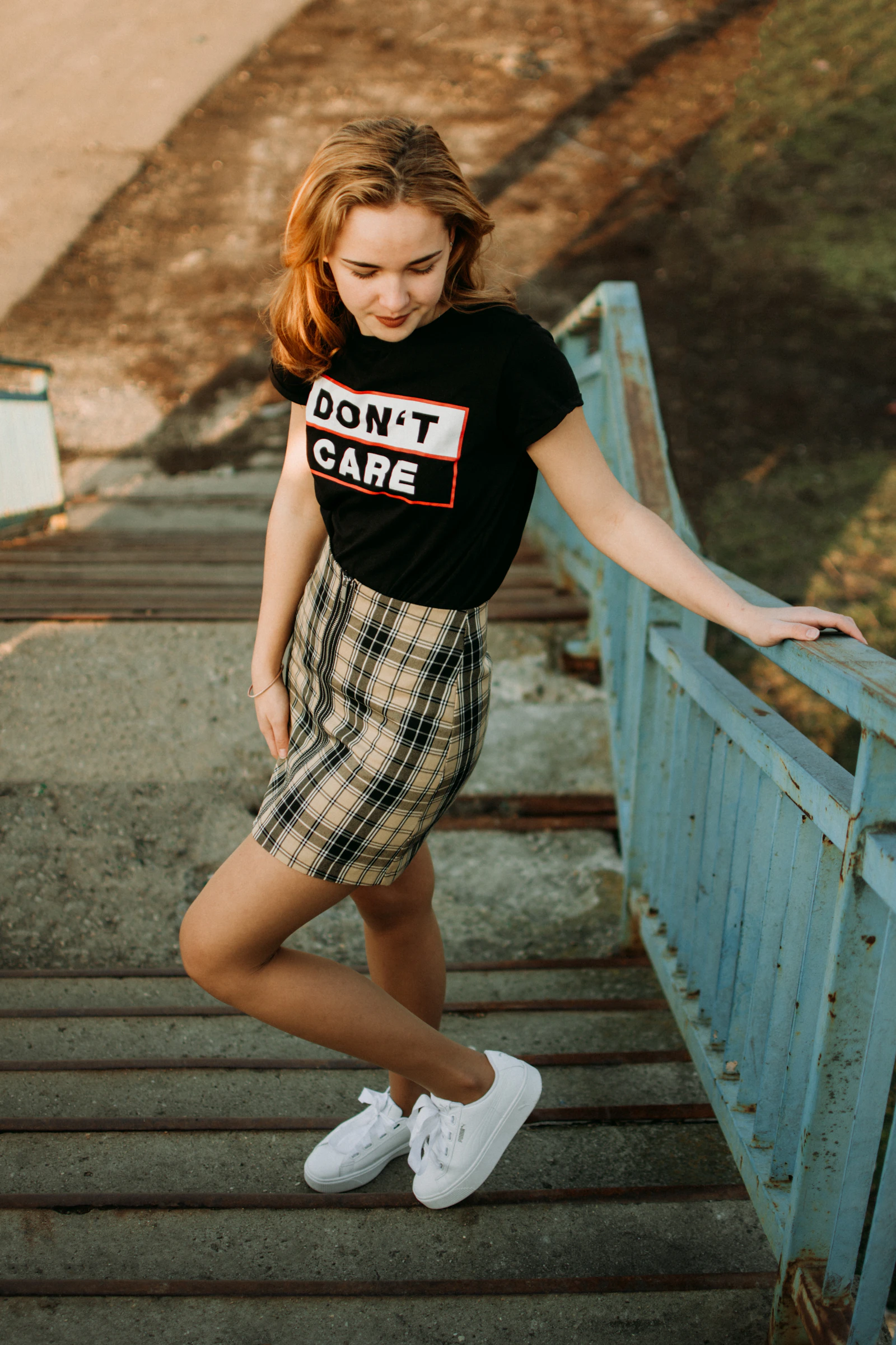 A woman pausing on a staircase, holding the rail and looking down, hesitating before she moves