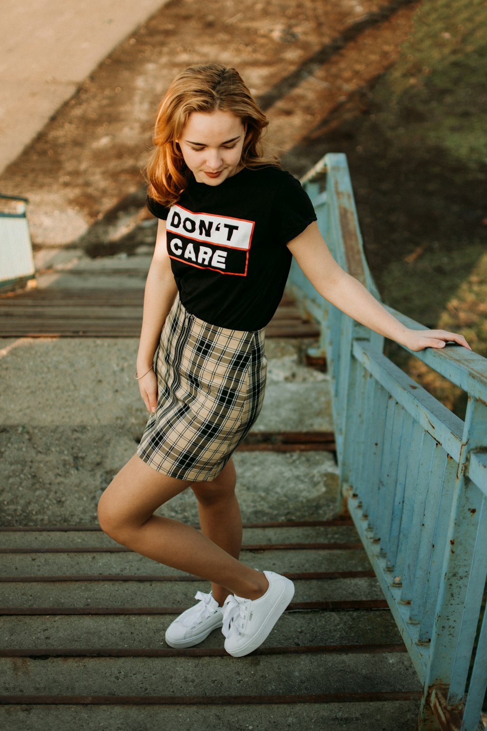 woman looking downward while holding on stairs