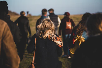 group of people walking on grass field