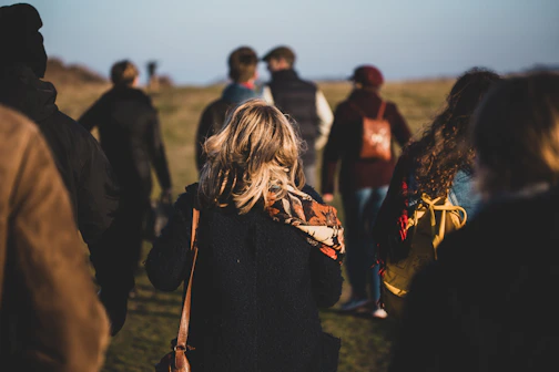 group of people walking on grass field