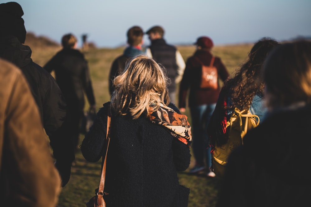 group of people walking on grass field