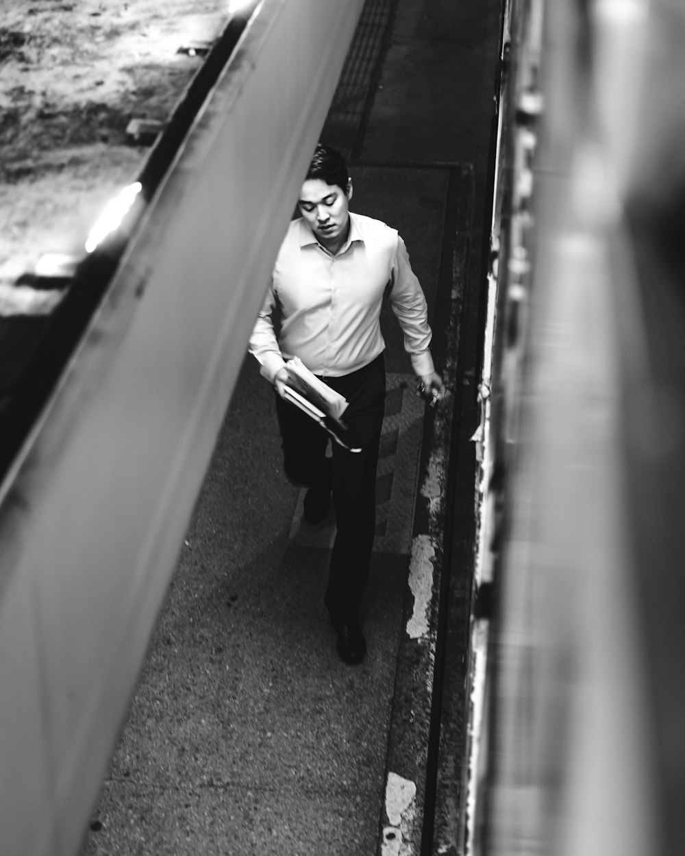 man in dress shirt and pants walking on sidewalk