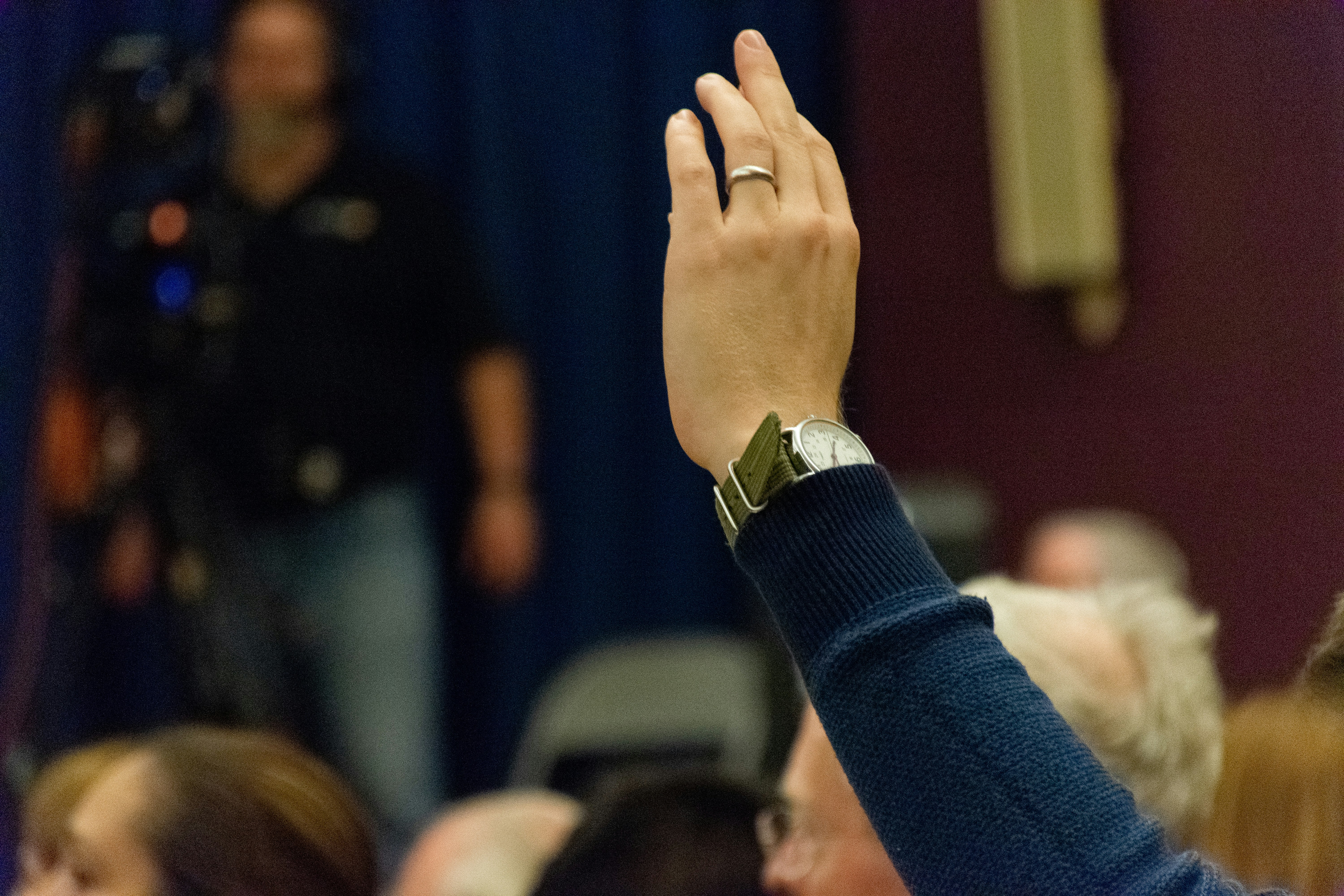 person wearing silver-colored ring rising above