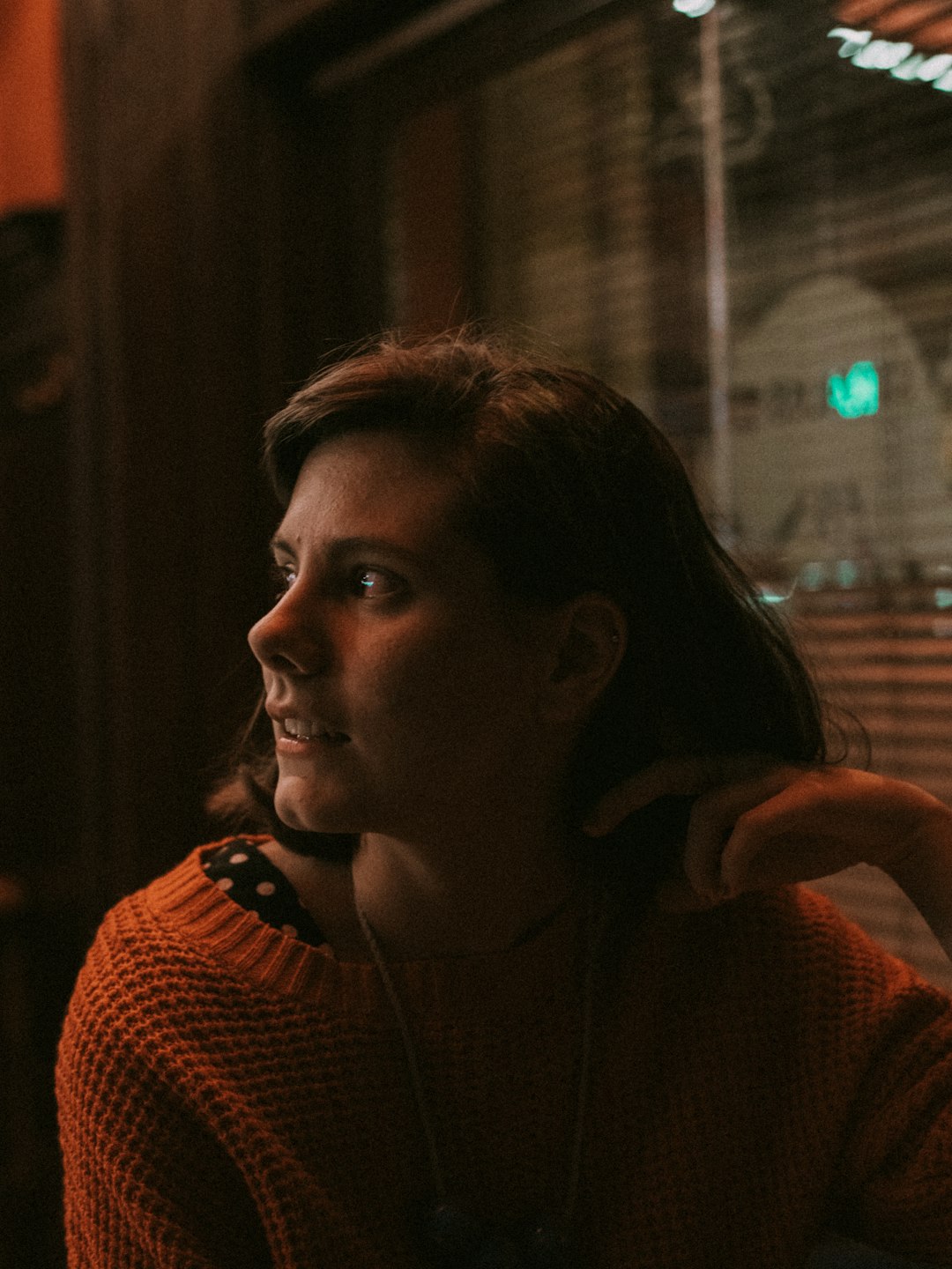 woman in brown sweater near window